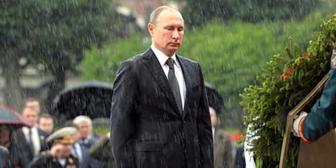 President of Russia Vladimir Putin wears a black suit in a rainstorm.