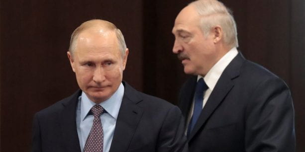 Vladimir Putin stands in front of Alexander Lukashenka